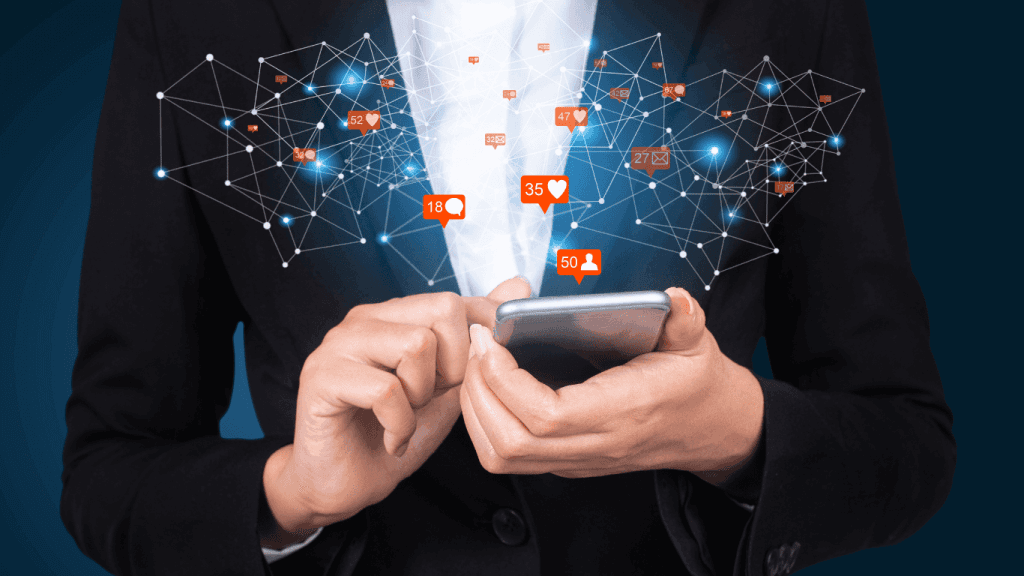 Person in a business suit holding a smartphone with floating social media notification icons and network connections radiating outward. The image represents digital communication social engagement and connected data networks.